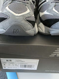 New Balance 9060s gray running shoes displayed on the box with size information.