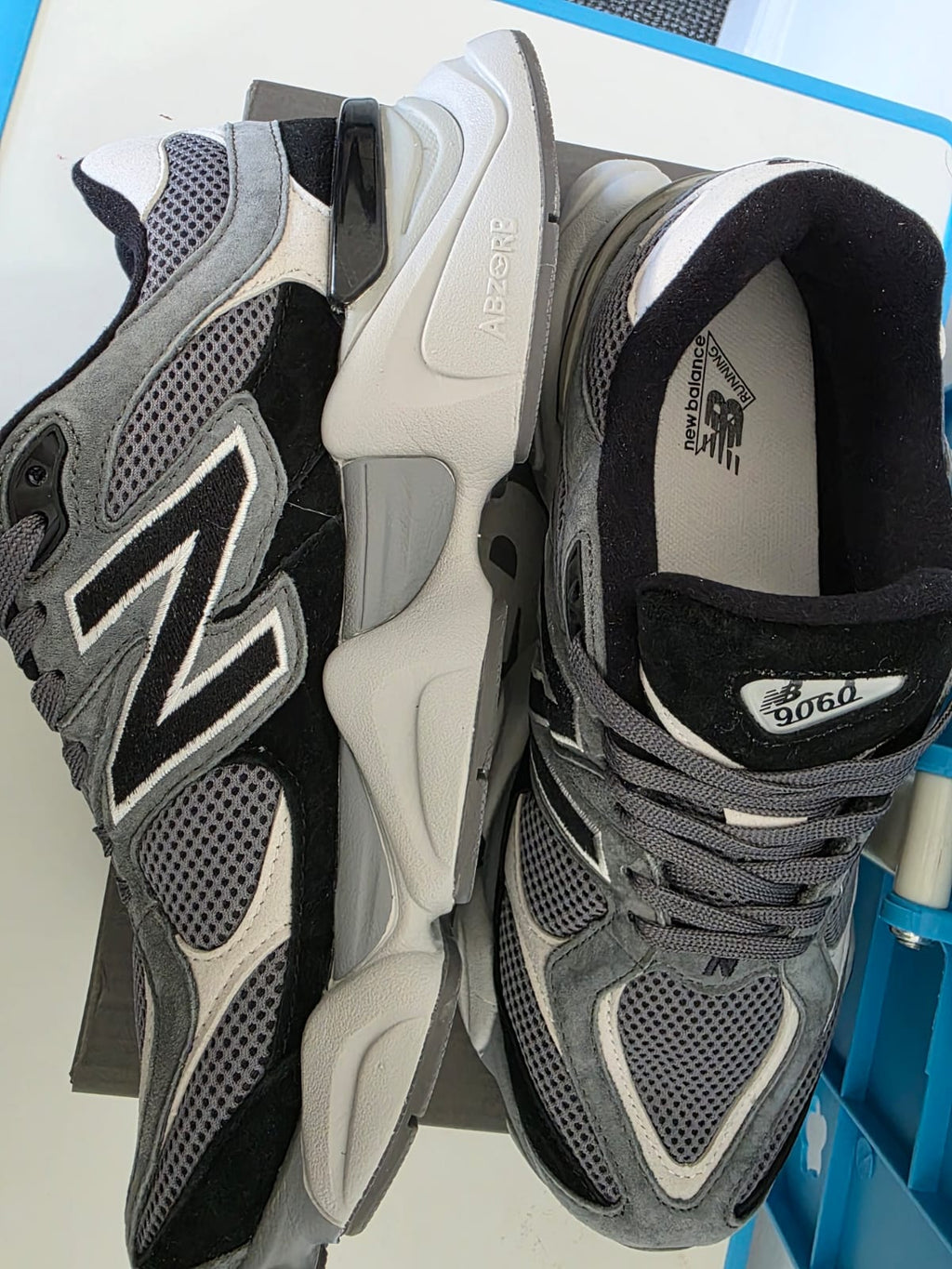 New Balance 9060s gray sneakers showcasing unique design and stylish appearance angled on a surface.