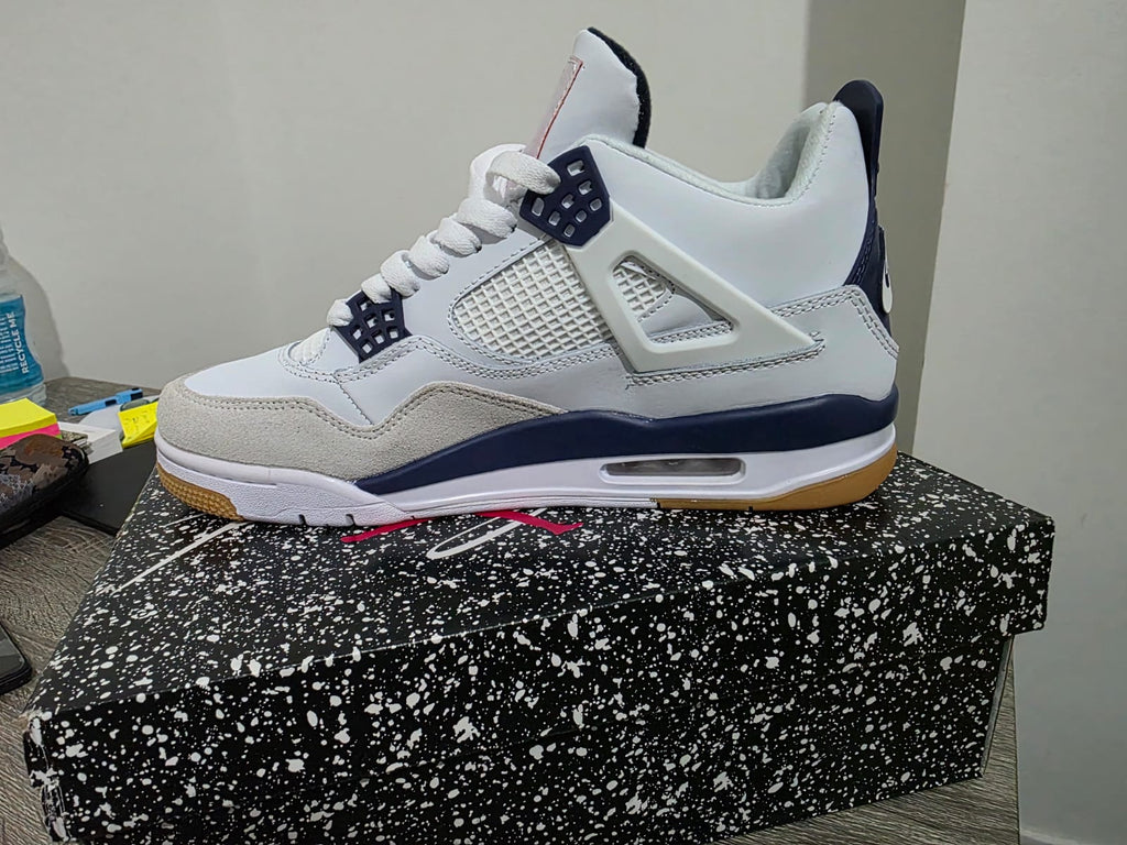 Nike Air Jordan 4 style trainers displayed on a speckled box, showcasing premium design and comfort.
