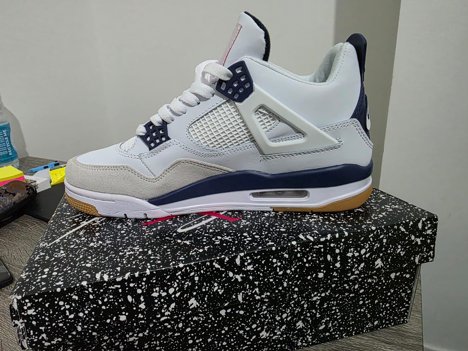 Nike Air Jordan 4 style trainers displayed on a speckled box, showcasing premium design and comfort.